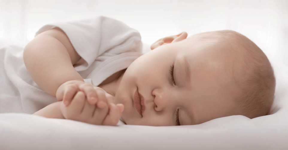 New born baby in white tee shirt sleeping on its side