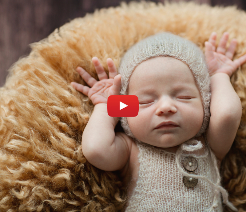 Newborn baby sleeping on plush rug