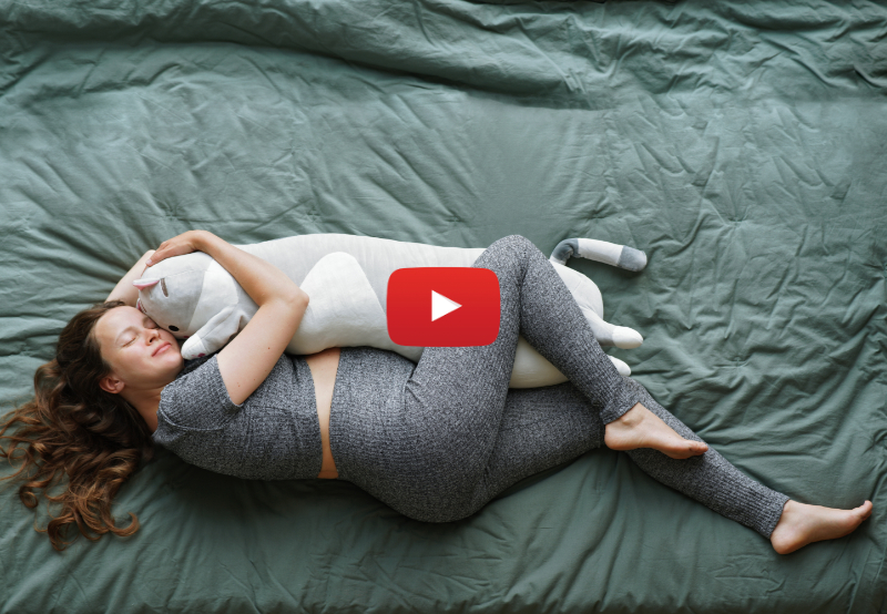 Pregnant woman sleeping on her side with a long pillow