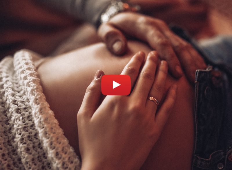 Woman and man with their hands on woman's pregnant belly